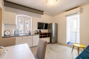 Una cocina con gabinetes blancos y un refrigerador de acero inoxidable. en Split Central City Apartment, en Split 10 fotos más