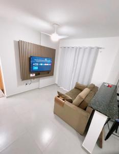 Apartamento vista mar 72 في برايا جراندي: غرفة معيشة مع أريكة وتلفزيون