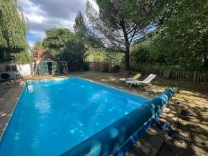 a large blue swimming pool in a yard at The Cottage, Marlow in Buckinghamshire