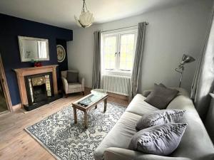 uma sala de estar com um sofá e uma mesa em The Cottage, Marlow em Buckinghamshire