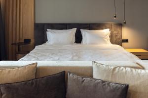 パナギュリシテにあるKamengrad Hotel & SPAの大型ベッド(白いシーツ、枕付)