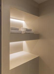 baño con toallas blancas en las estanterías en Kamengrad Hotel & SPA, en Panagyurishte