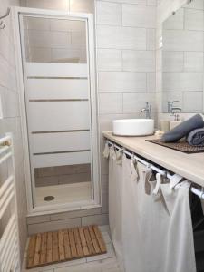 a white bathroom with a sink and a shower at Cocoon urbain : Aux portes des JO et de Disney in Vaires-sur-Marne