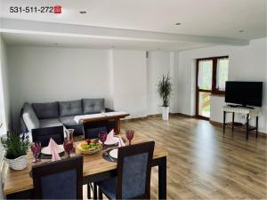 ein Wohnzimmer mit einem Tisch und einem Sofa in der Unterkunft Apartament w Budzowie in Budzów