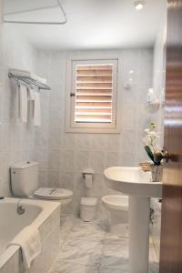 a white bathroom with a toilet and a sink at Vista Alegre in Benicàssim