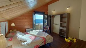 a bedroom with a bed and a large window at Chalet 360 l Essenti Aile, Gerardmer La Mauselaine in Gérardmer