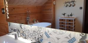 a bathroom with a tub and a sink with a mirror at Chalet 360 l Essenti Aile, Gerardmer La Mauselaine in Gérardmer