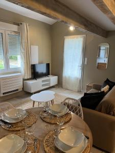 ein Wohnzimmer mit einem Tisch und einem TV in der Unterkunft Appartements St. Pancrace in Corte