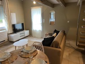 a living room with a couch and a tv at Appartements Saint Pancrace in Corte +12 photos