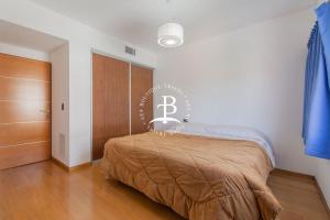 - une chambre avec un lit et une couverture brune dans l'établissement Tríplex Moderno con parrilla y jardín- Baires !, à Buenos Aires