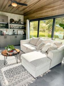 sala de estar con sofá blanco y mesa en Modern Tiny Home, 