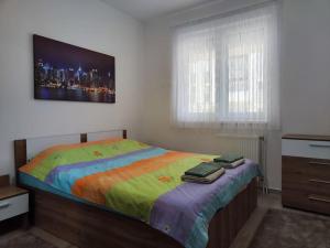 1 dormitorio con 1 cama con una manta colorida en MINT Apartment, en Skopje