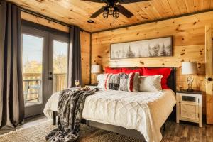 a bedroom with a bed with red pillows at Mountainscape - Brand New Cabin w Views - HotTub - FireTable - PS5 - PoolTable - 3 Pools in Gatlinburg