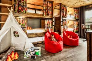 a room with two red chairs and a tent at Mountainscape - Brand New Cabin w Views - HotTub - FireTable - PS5 - PoolTable - 3 Pools in Gatlinburg