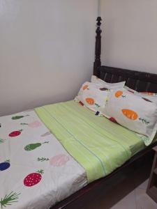 a bed with fruits and vegetablespillows on it at OKRA HOUSE in Entebbe