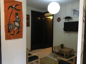 uma sala de estar com uma mesa e um quadro na parede em OKRA HOUSE em Entebbe