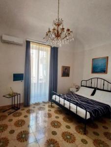 a bedroom with a bed and a chandelier at 4Tino in Catania