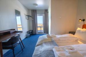 una camera d'albergo con 2 letti e una scrivania di Skulagardur Country Hotel a Garður
