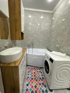 La salle de bains est pourvue d'un lave-linge et d'un lavabo. dans l'établissement ЖК Керемет Ашимова 21А, à Fëdorovka