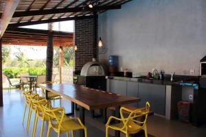 uma cozinha com uma mesa de madeira e cadeiras amarelas em Chacara Alto Padrão Recanto Felicidade Paraopeba em Paraopeba