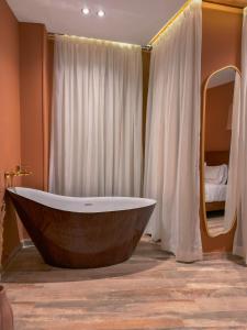 un bagno con ampia vasca e una camera da letto di Jimmy Pyramids Hotel a Il Cairo