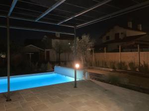 a swimming pool at night with a solarium at Chai Nous in Rion-des-Landes