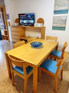 una mesa de madera con sillas y un plato. en Tranquilo apartamento con vistas al mar. en Port d'Alcudia