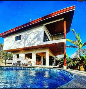 una casa con piscina frente a ella en Casa Kapai en Nosara