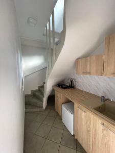 a kitchen with a staircase and a sink in a room at Apartament Juratka in Jurata