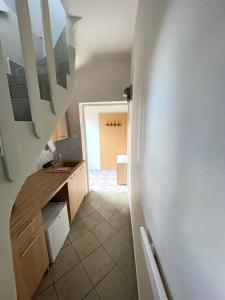 a small kitchen with a counter and a hallway at Apartament Juratka in Jurata