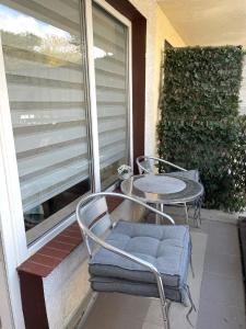 a patio with two chairs and a table and a window at Apartament Juratka in Jurata