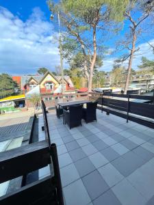 a group of benches and tables on a patio at Apartament Juratka in Jurata