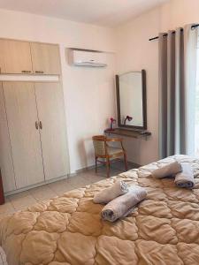 een slaapkamer met een groot bed met een spiegel en een bureau bij Grand House in Agios Nikolaos