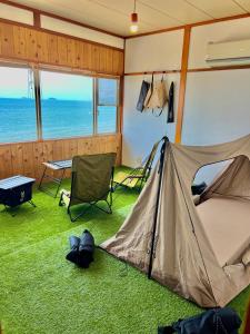 Zelt in einem Zimmer mit Tisch und Stühlen in der Unterkunft ASTERISK＋ in Iwami