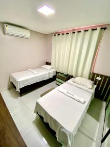 a hospital room with two beds and a window at Residencial renaissance in Boa Vista