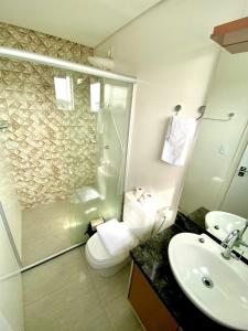 a bathroom with a toilet and a shower and a sink at Residencial renaissance in Boa Vista +22 photos