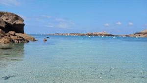 a large body of water with a bunch of rocks at Hébergement, Au couché du soleil in Lannion