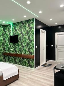 een slaapkamer met een muur met groen behang bij Hotel MoonLight in Fier