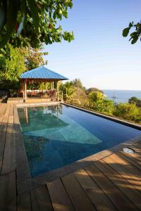 uma piscina com um gazebo e o oceano em El Xalli em El Zonte