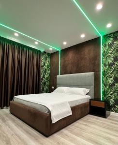 um quarto com uma cama grande e luzes verdes em Hotel MoonLight em Fier
