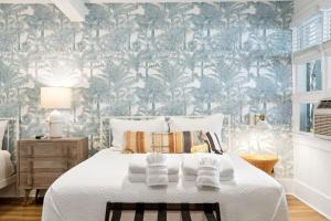 a bedroom with a bed with a tropical wallpaper at Folliday Inn - The Boattail - Room 15 in Folly Beach