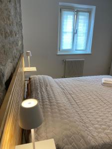 una camera da letto con un letto con una lampada e una finestra di Appartamento Scaligeri a Venzone