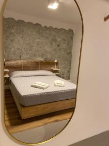 espejo reflejo de una cama en una habitación en Appartamento Scaligeri, en Venzone