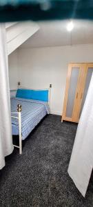 um quarto com uma cama com lençóis azuis e uma janela em MC Suites em Old Walker
