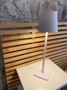 una lámpara blanca sentada sobre una mesa blanca en Appartamento Scaligeri, en Venzone
