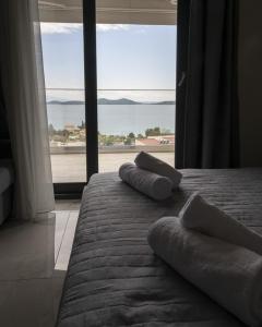 a bedroom with two beds and a large window at ALTA MARE in Nea Peramos