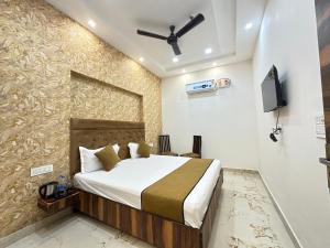 a bedroom with a bed and a tv on a wall at Hotel EMBASSY 250 Meter From Golden Temple in Amritsar