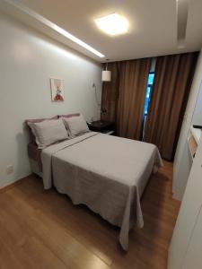 a bedroom with a large white bed in a room at Queen's Flats in Brasília