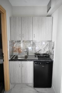 a kitchen with a sink and a black dishwasher at ALTA MARE in Nea Peramos