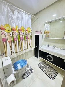 a bathroom with a shower curtain and a toilet and a sink at Holiday triplex house in Gabès
